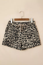 Leopard print shorts on a hanger against a beige background