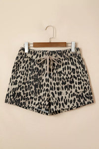 Leopard print shorts on a hanger against a beige background