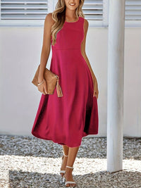 Woman wearing a red dress holding a brown clutch against a white background