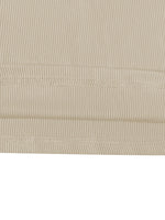 Close-up of beige ribbed fabric with visible stitching on a white background