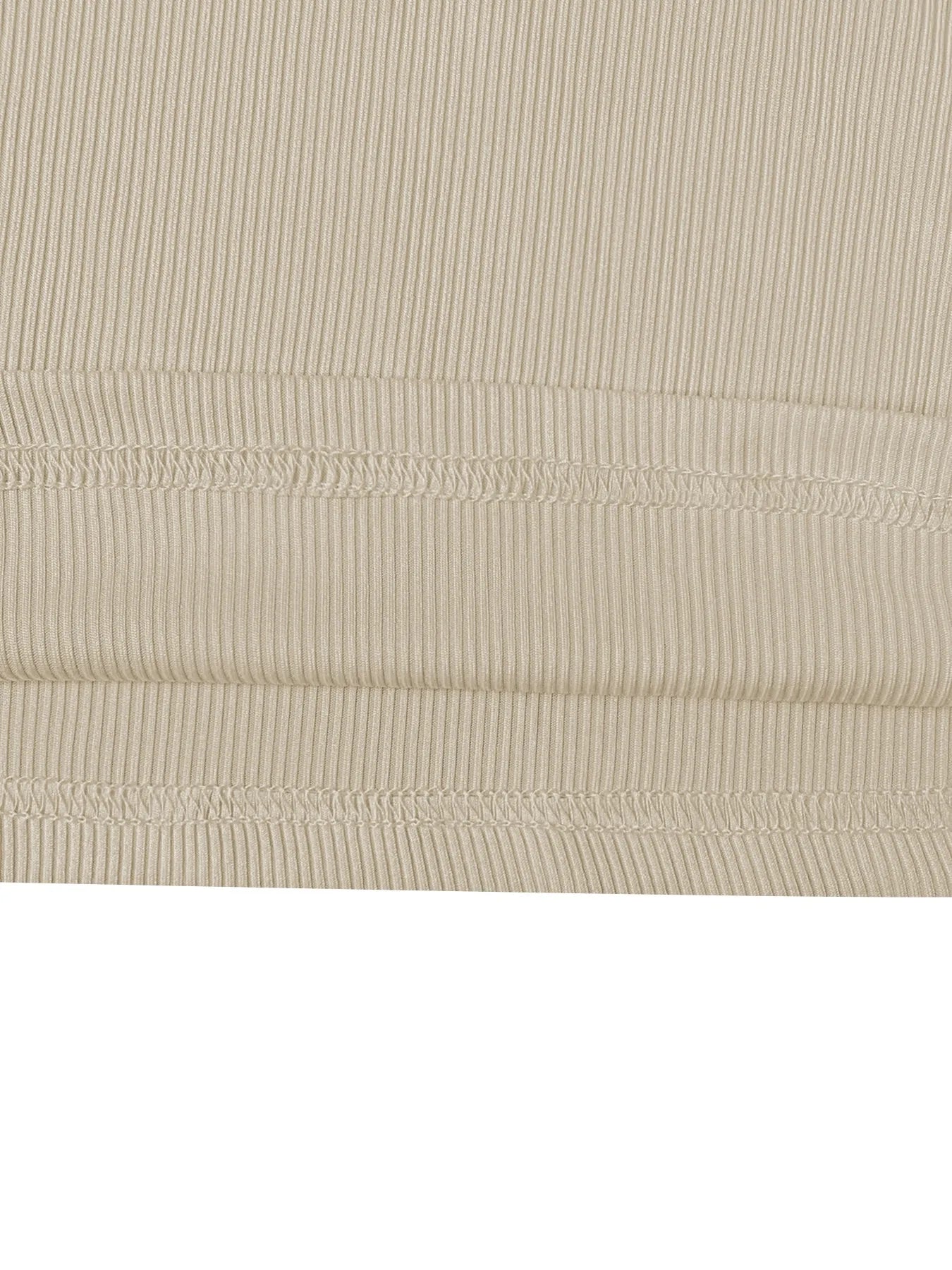 Close-up of beige ribbed fabric with visible stitching on a white background