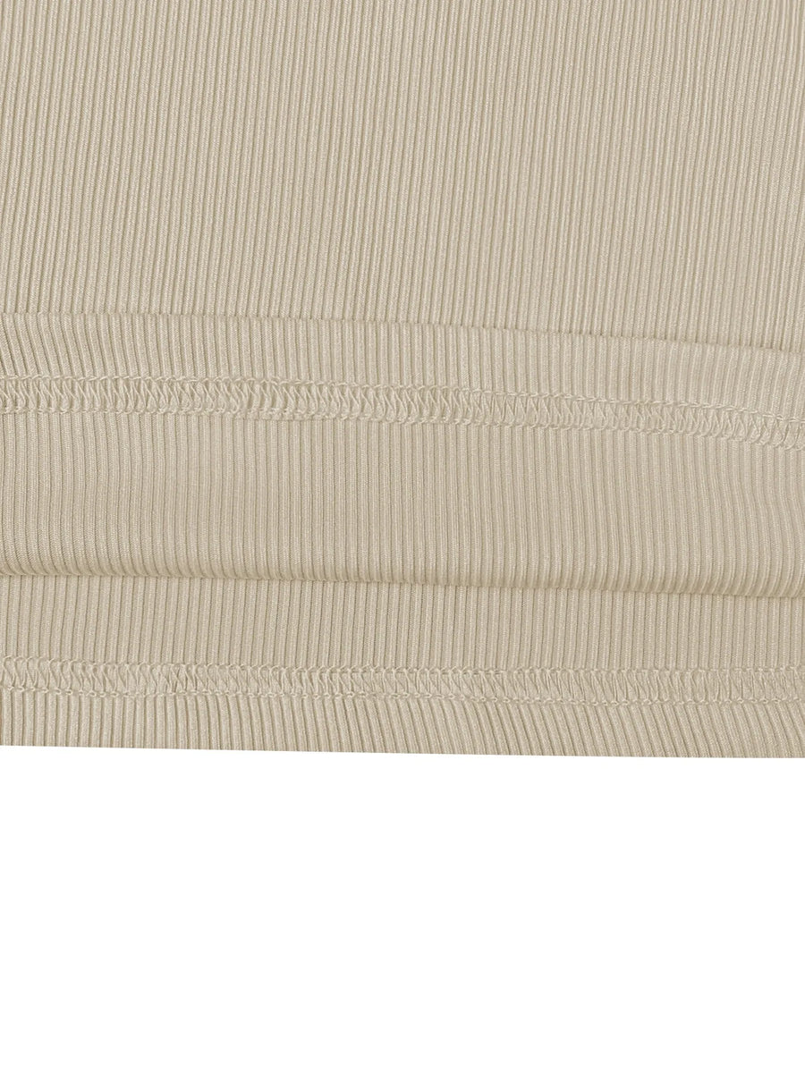 Close-up of beige ribbed fabric with visible stitching on a white background