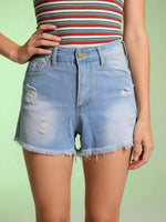 Person wearing a striped crop top and light blue denim shorts on a green background