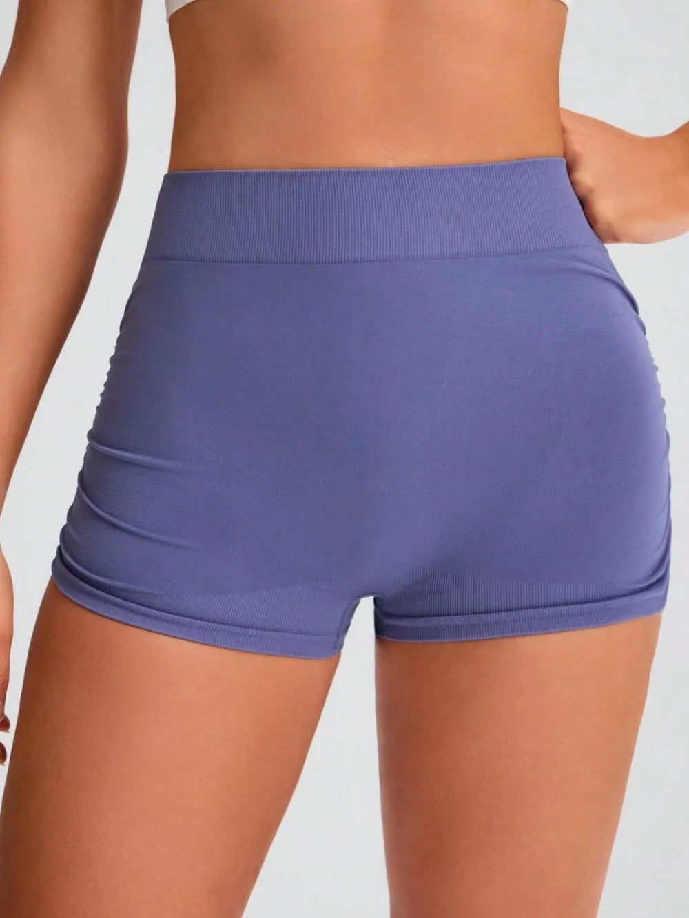 Purple athletic shorts worn by a person on a plain background