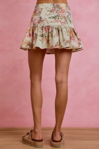 Floral skirt worn by a person on a pink background