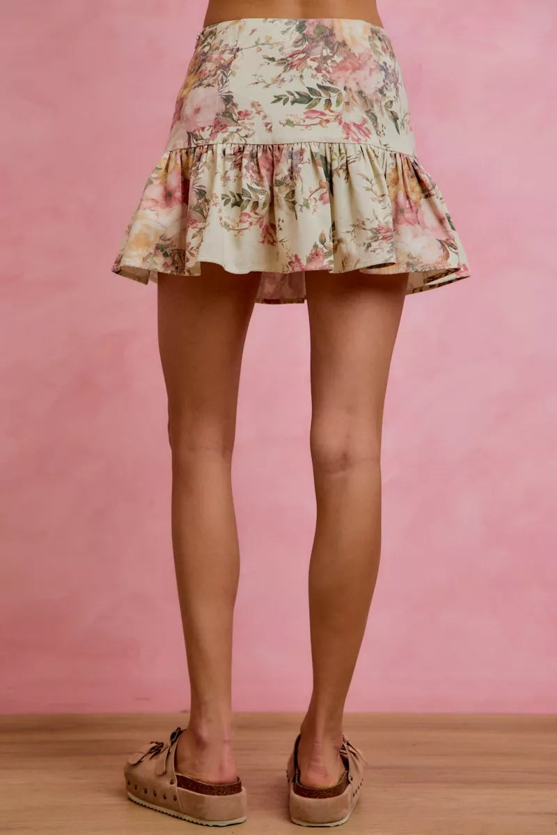 Floral skirt worn by a person on a pink background