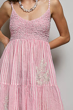 Pink dress with floral embellishments on a plain background