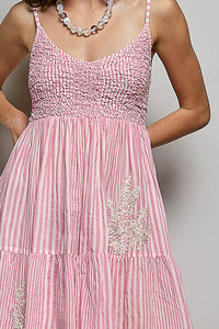 Pink dress with floral embellishments on a plain background
