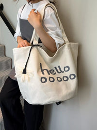 Person holding a white tote bag with 'hello o0000' text.
