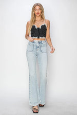 Woman wearing a black lace top and light blue jeans on a white background