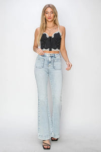 Woman wearing a black lace top and light blue jeans on a white background