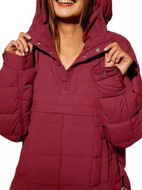 Person wearing a maroon hooded jacket on a white background