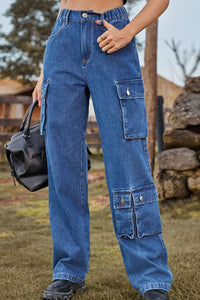Person wearing blue cargo jeans holding a black bag outdoors.
