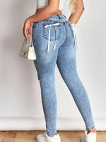 Light blue jeans with drawstring waist worn by a person on a plain background