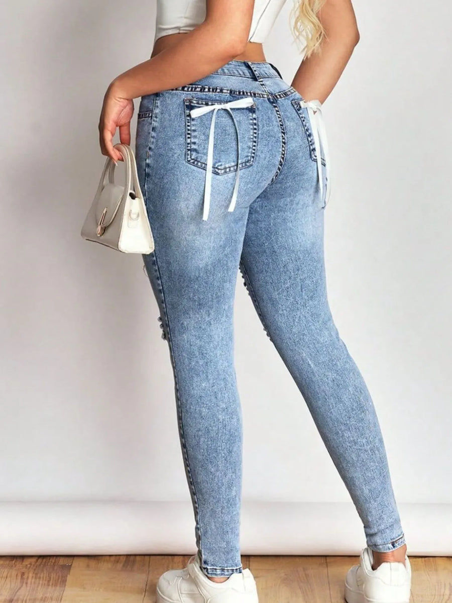 Light blue jeans with drawstring waist worn by a person on a plain background