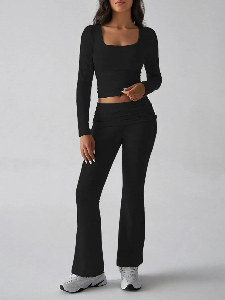 Person wearing a black long-sleeve top and black pants on a gray background