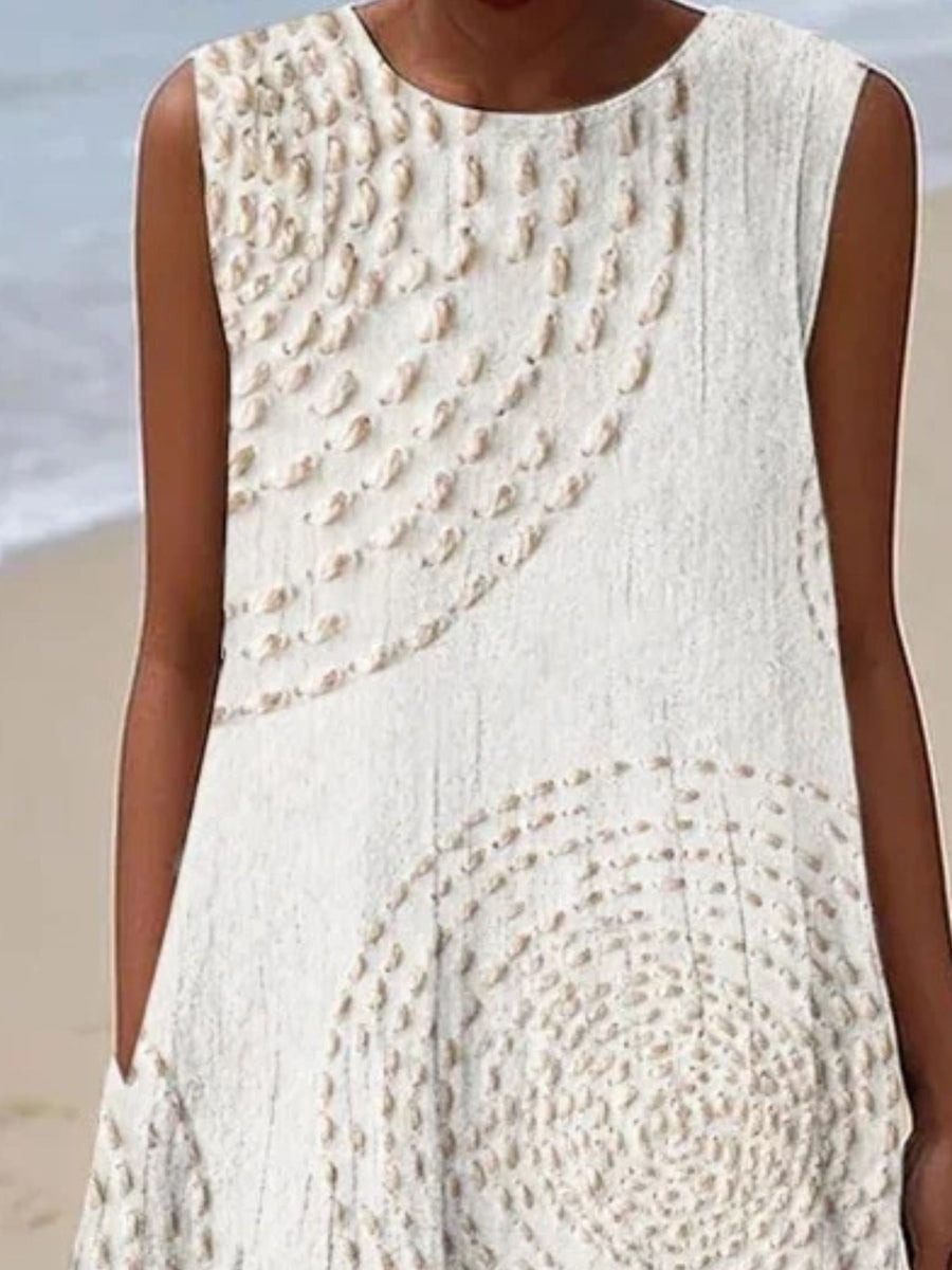 White sleeveless dress with textured pattern worn by a person on a beach.