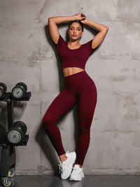 Person wearing a maroon athletic outfit posing in a gym setting