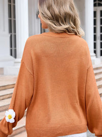 Person wearing a brown sweater with a blurred background
