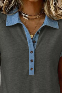 Gray polo shirt with blue collar and buttons, worn by a person.