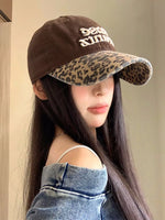Person wearing a brown cap with leopard print brim and 'Peace Love' text.