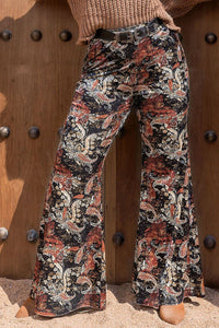 Floral patterned pants worn by a person against a wooden background