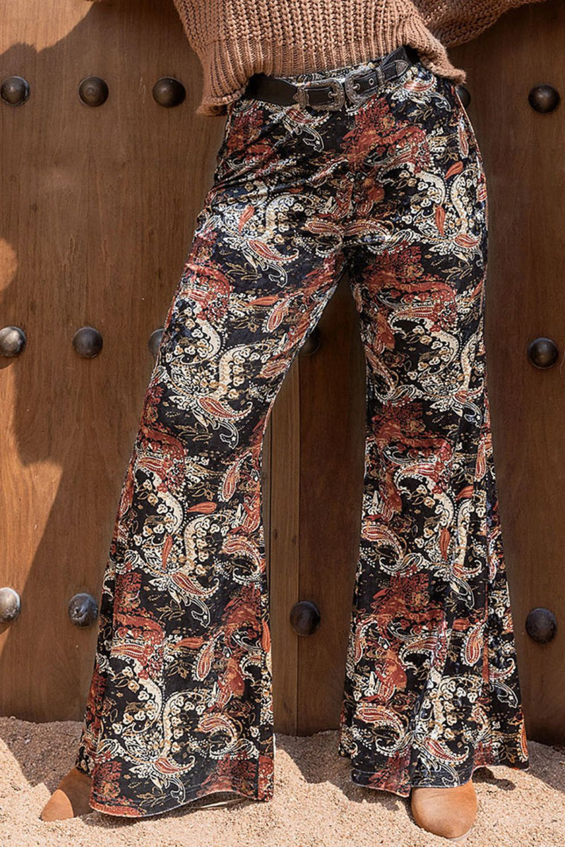 Floral patterned pants worn by a person against a wooden background