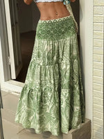 Green patterned skirt being held by a person against a neutral background