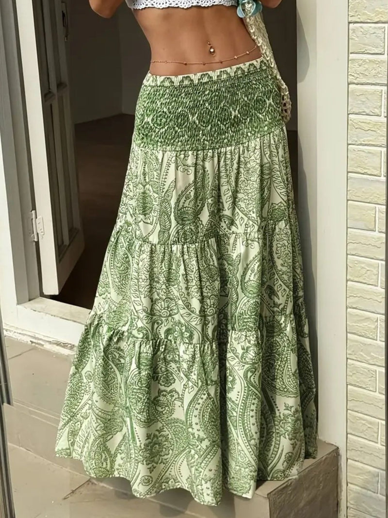 Green patterned skirt being held by a person against a neutral background