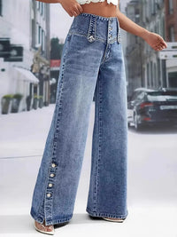 Person wearing high-waisted blue jeans on a city street.