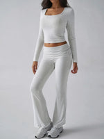 Person wearing a gray long-sleeve top and pants on a white background