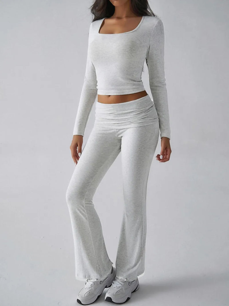 Person wearing a gray long-sleeve top and pants on a white background