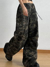 Camouflage pants worn by a person on a plain background