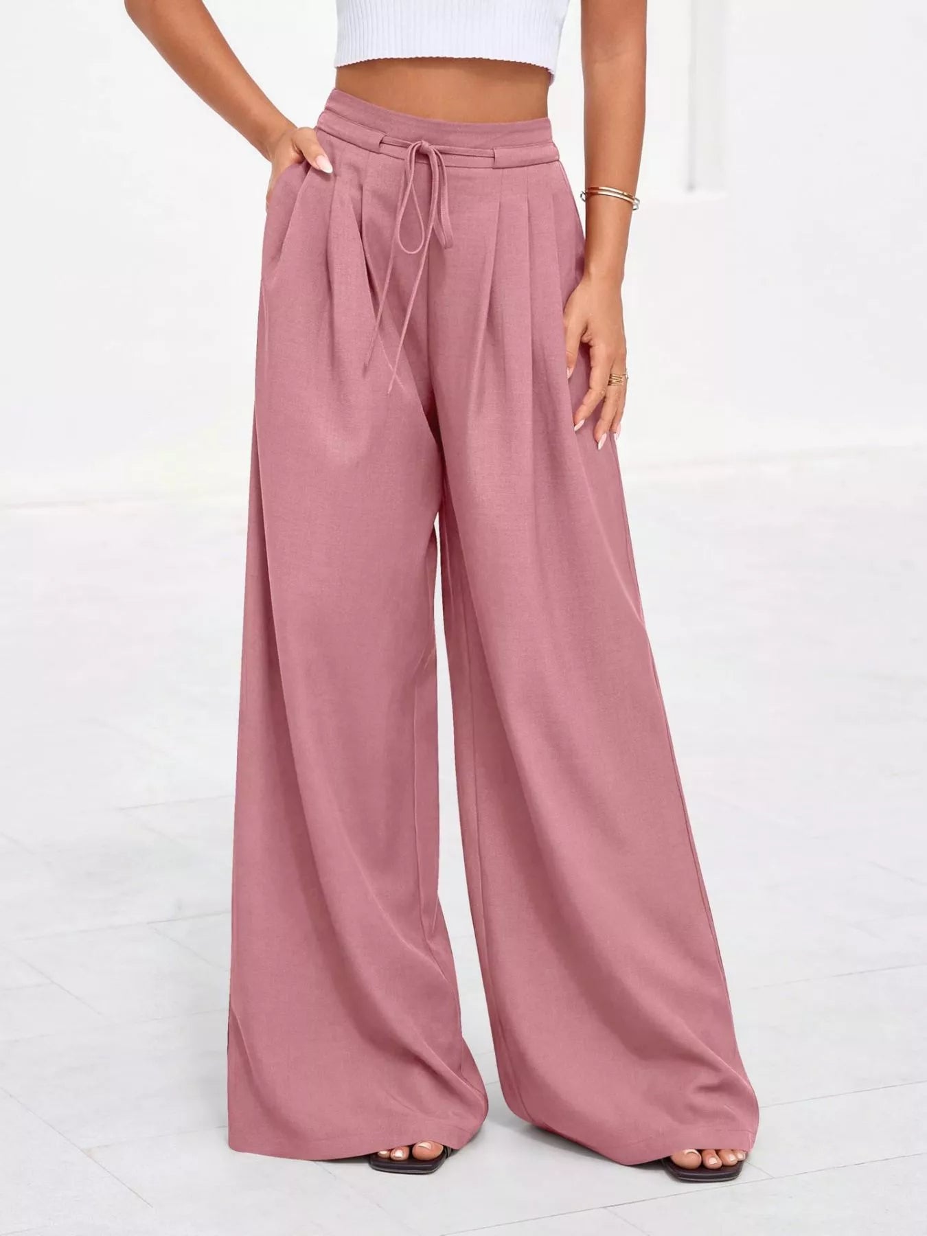 Pink wide-leg pants worn by a person on a white background