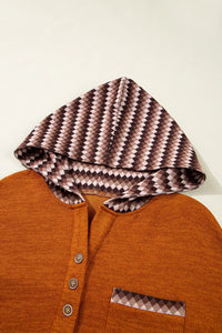 Brown hooded jacket with patterned lining on a white background