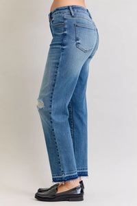 Blue jeans worn by a person on a plain background