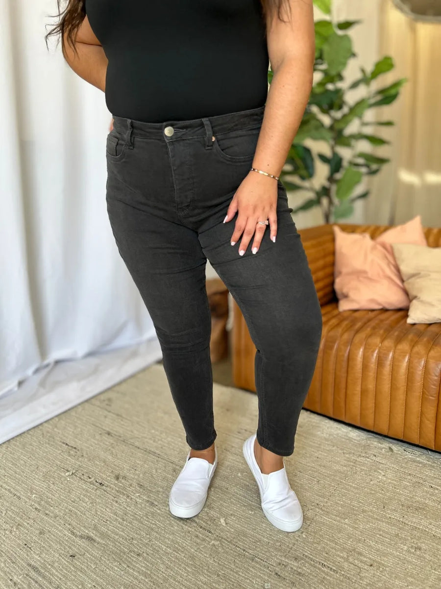 Person wearing black jeans and white shoes in a living room setting