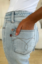 Close-up of a person wearing light blue jeans with a blurred background