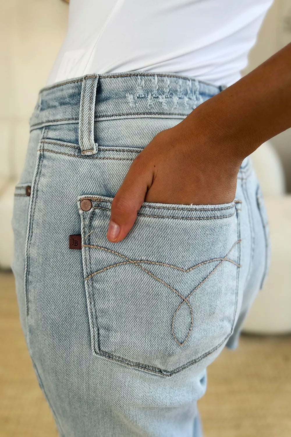 Close-up of a person wearing light blue jeans with a blurred background