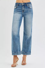 Blue jeans worn by a person on a light gray background
