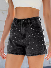 Black denim shorts with rhinestone embellishments worn by a person.