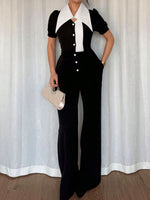 Person wearing a black and white outfit with a white curtain background
