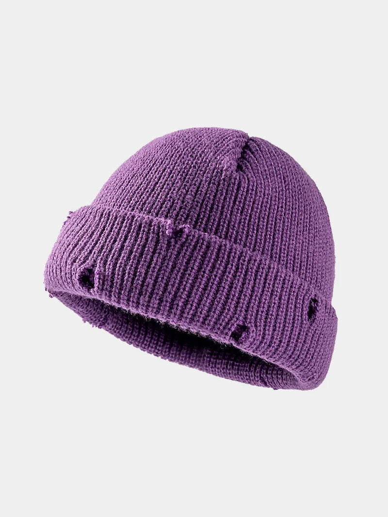 Purple knit beanie with black dots on a white background