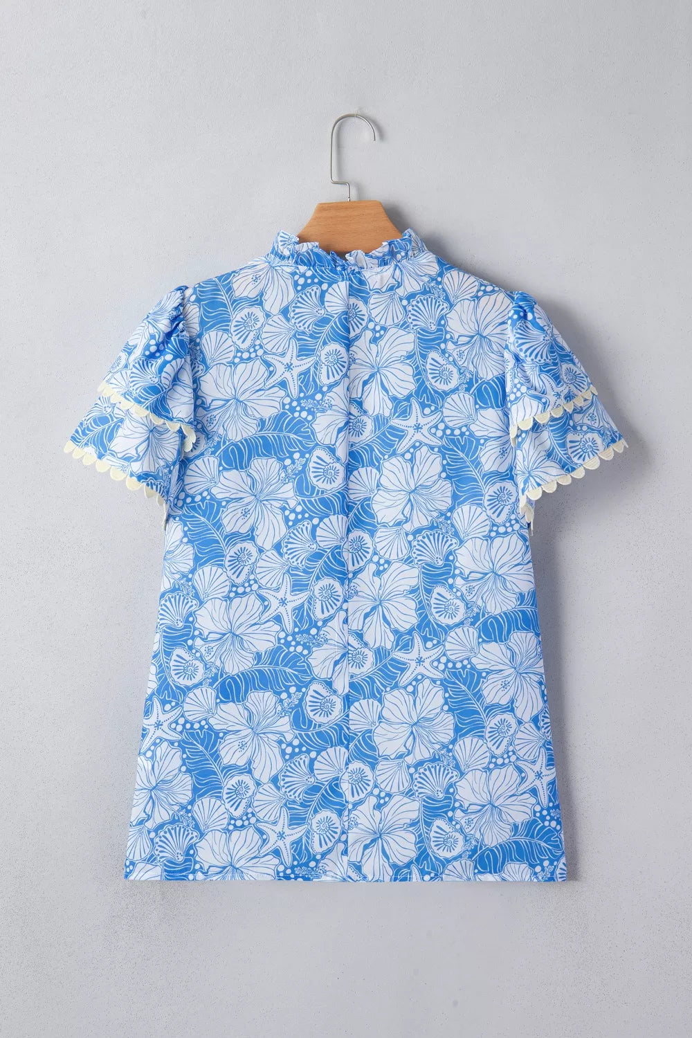 Blue floral dress with white ruffles on a gray background