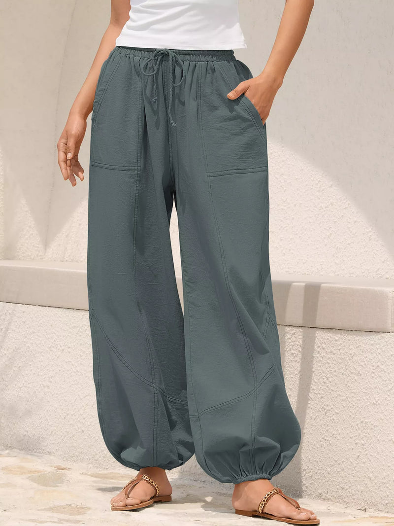Person wearing teal wide-leg pants on a neutral background