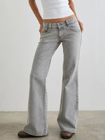 Person wearing light gray flared jeans on a plain background