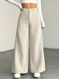 Person wearing beige wide-leg pants with a plain background