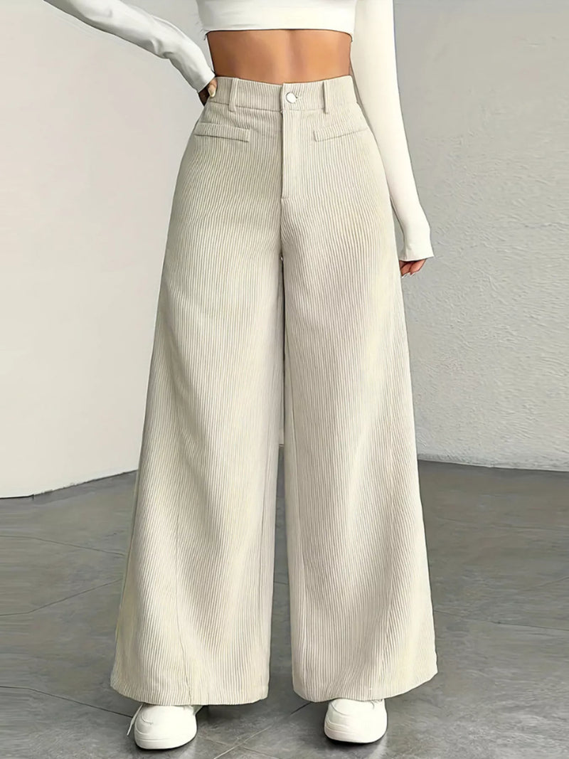 Person wearing beige wide-leg pants with a plain background