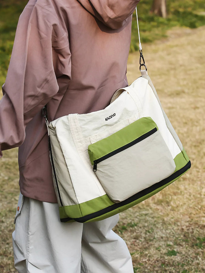 Person holding a beige and green bag outdoors