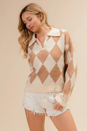 Woman wearing a diamond patterned sweater and white shorts on a beige background